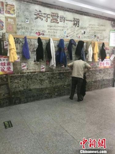 市民在“爱心墙”旁挑选衣物 王天译 摄 市民在“爱心墙”旁挑选衣物 王天译 摄