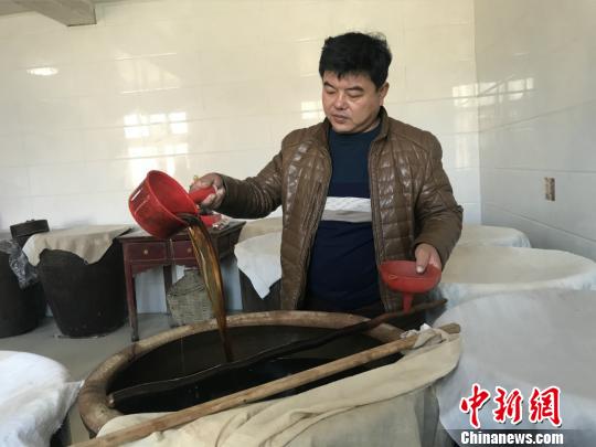 图为仇彦军检查成醋品质。　张帆摄
